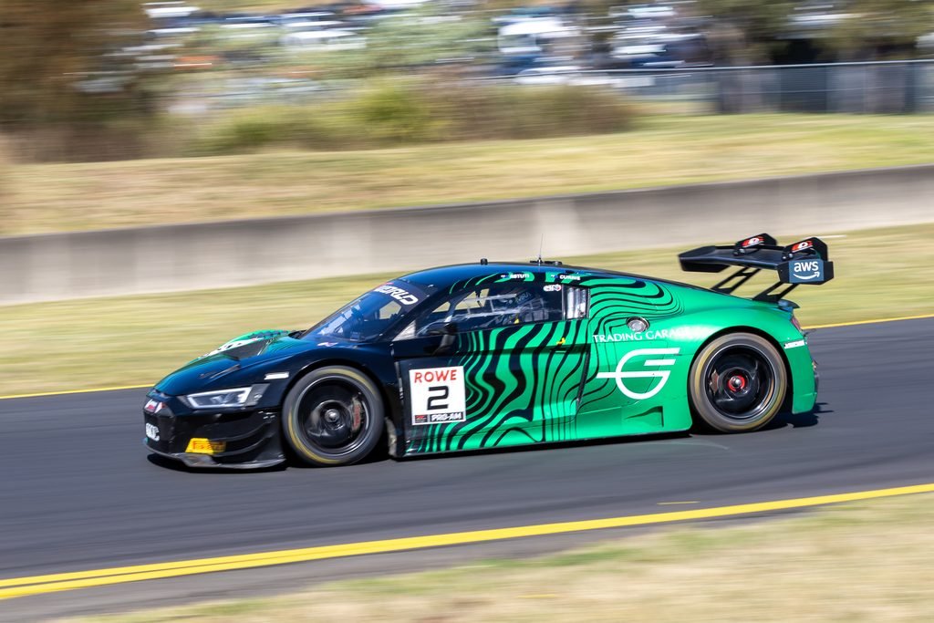 0I1A0192 • Sports Rewind Media Green and black striped race car #2 speeding along a race track with motion blur in the background on the left side of the image.