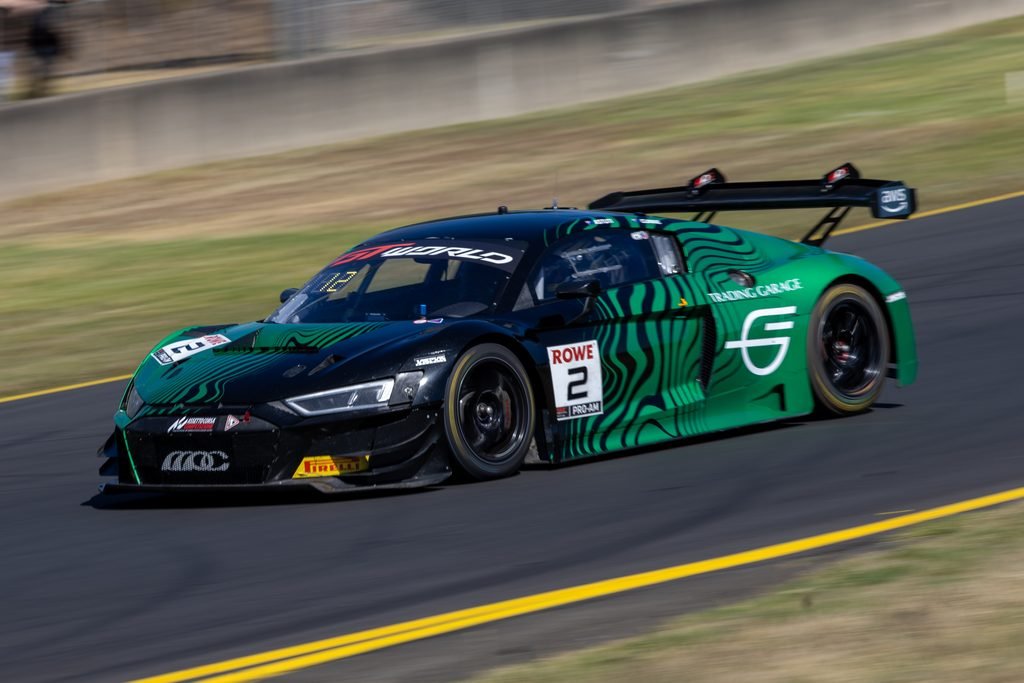0I1A0239 • Sports Rewind Media Green and black zebra-striped race car speeding along a racetrack, rear wing visible in motion blur of the trackside scenery.