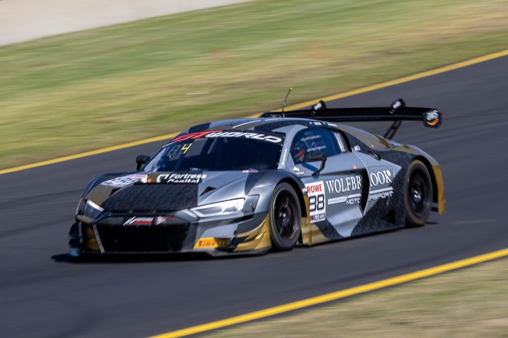 0I1A0240 • Sports Rewind Media Gray race car, number 88, with sponsor decals, speeding along a race track with motion blur in the background.