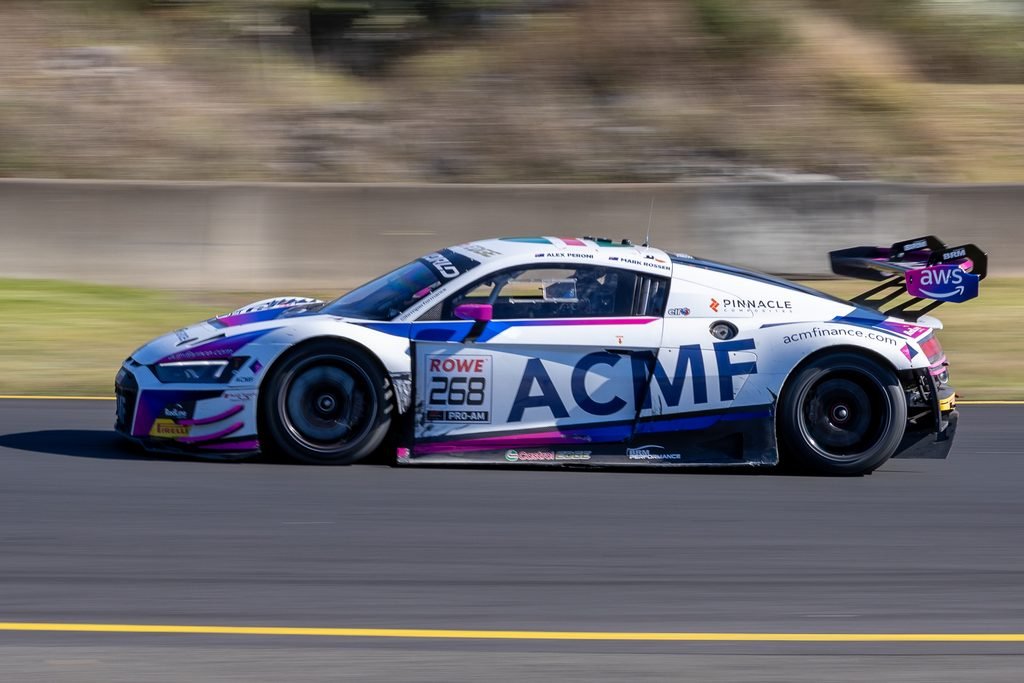 0I1A2480 • Sports Rewind Media White race car with blue and pink accents speeding on a track, sponsor logos visible (ACME, AWS, Pinnacle).