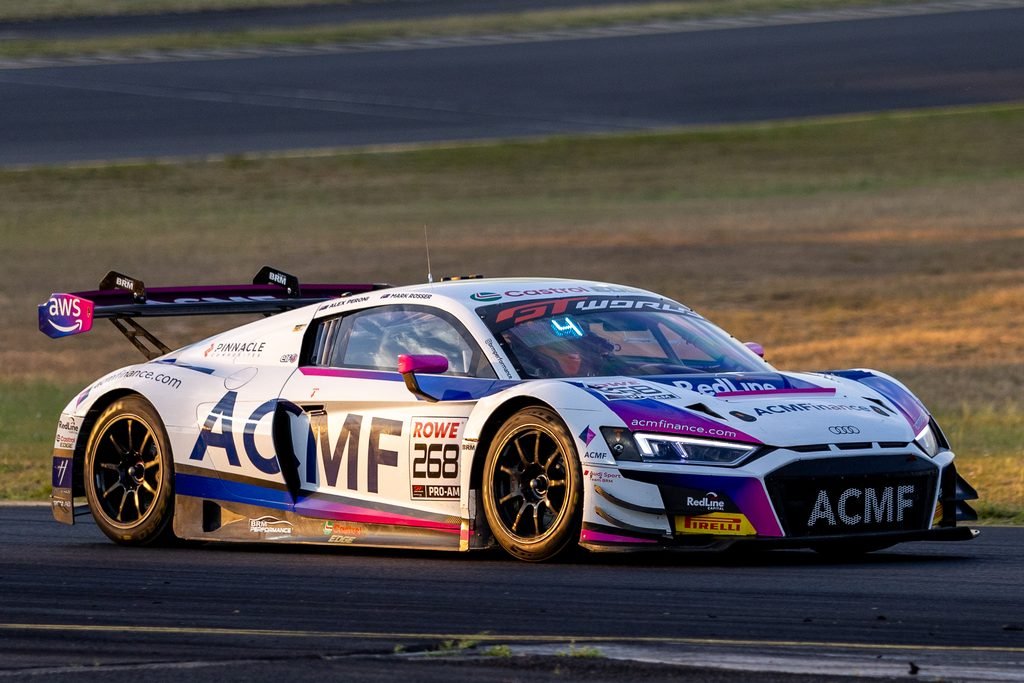 _I1A1605 • Sports Rewind Media White race car with pink and purple accents, number 268, speeding on a track with sponsor logos like ACME and RedLine visible on the body.
