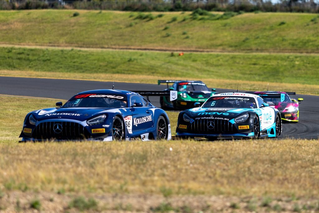 _I1A2388 • Sports Rewind Media Race cars in a pack on a curving race track with grassy infield and a blue Mercedes leading the group