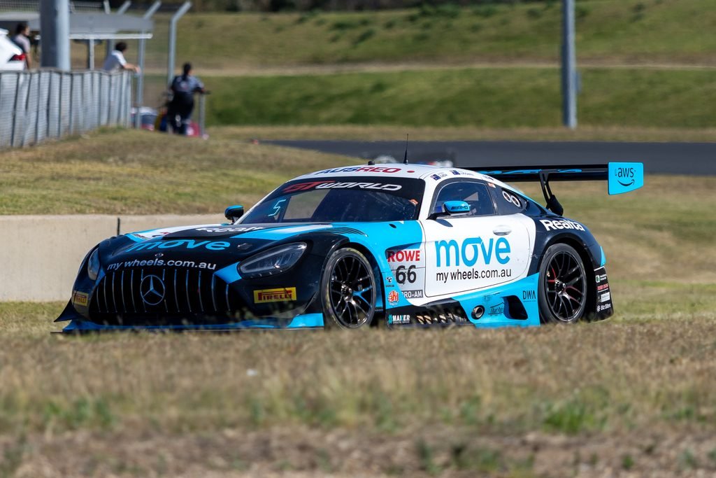 _I1A2414 • Sports Rewind Media Blue and white race car with MOVE branding speeds along a racetrack, grass backdrop.