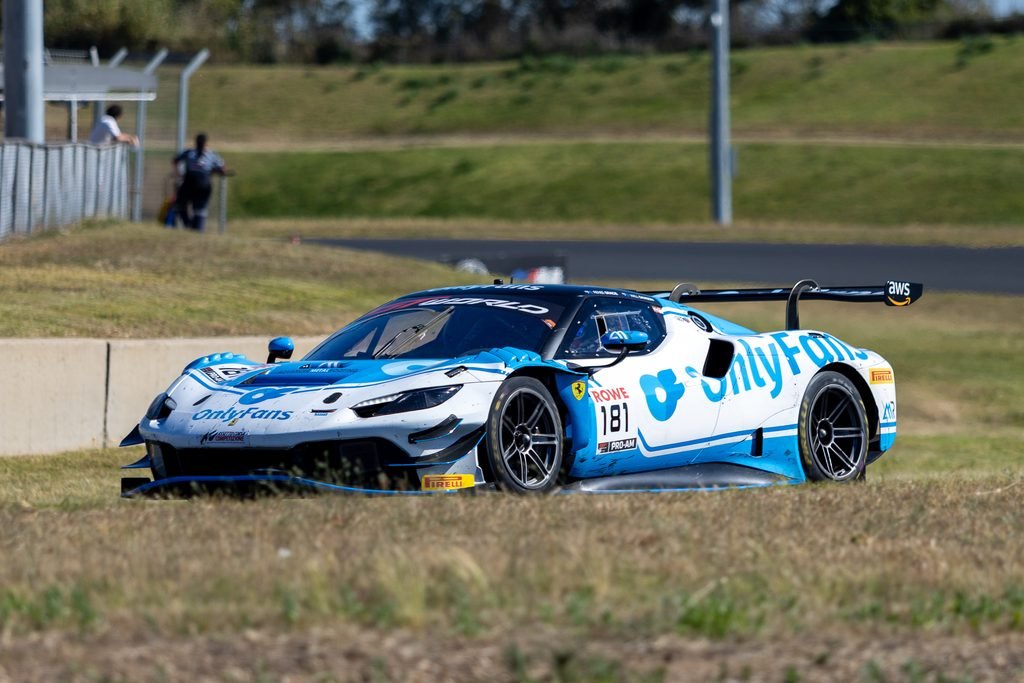 _I1A2418 • Sports Rewind Media Blue and white race car number 81 speeding on a track with grass in the foreground and blurred spectators in the distance.
